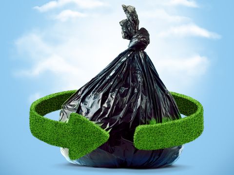 Müllsack und grüne Pfeile aus Gras. Recycling-Konzept
