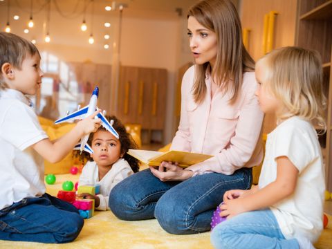 Erzieherin spielt mit Kita-Kindern