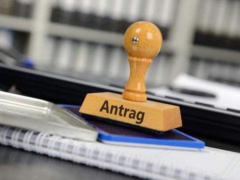 Stempel mit der Aufschrift 'Antrag' steht auf einem Stempelkissen